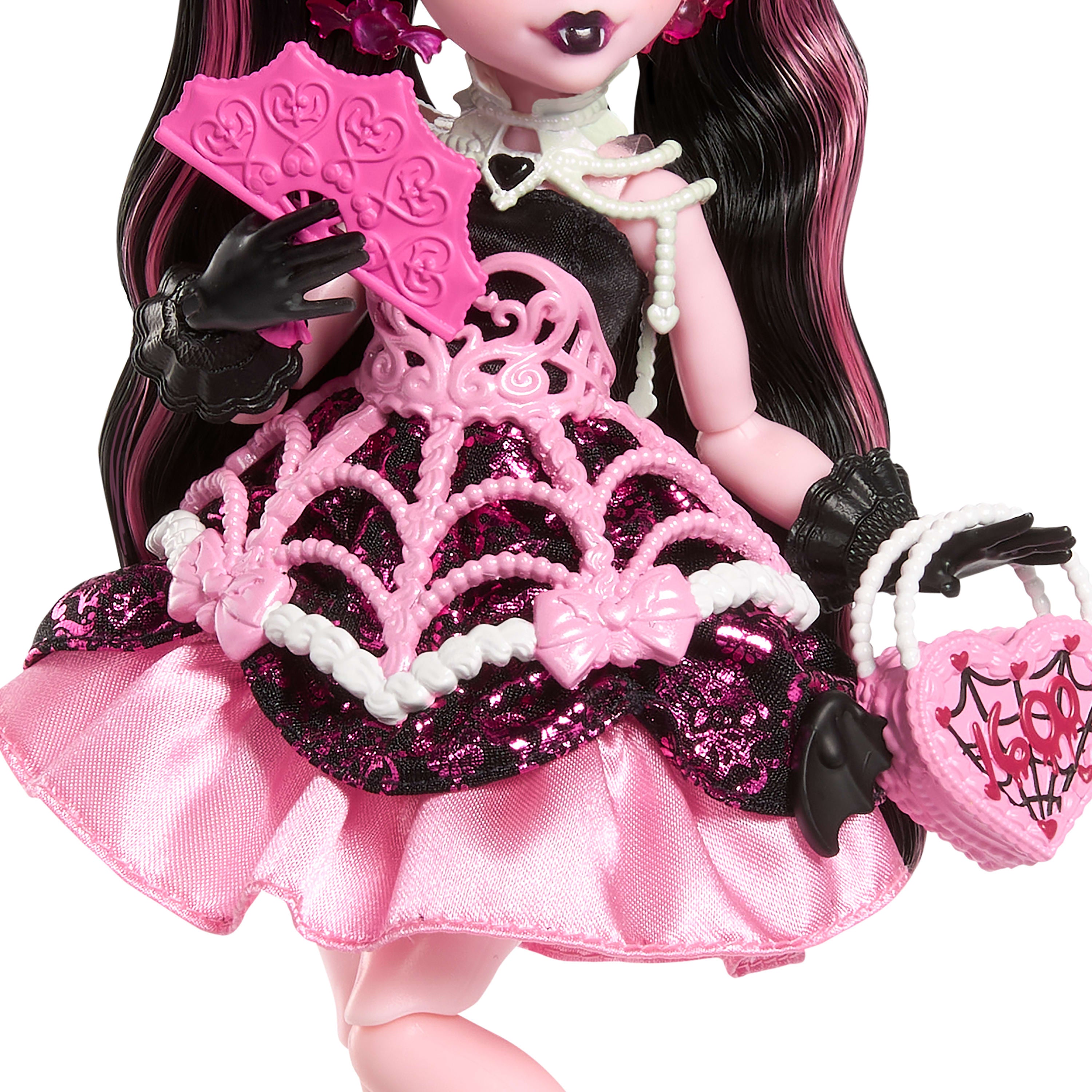 Parti elbisesi giyen ve bir elinde balon, diğer elinde hediyesini tutan Monster High Doğum Günü Draculaura bebek