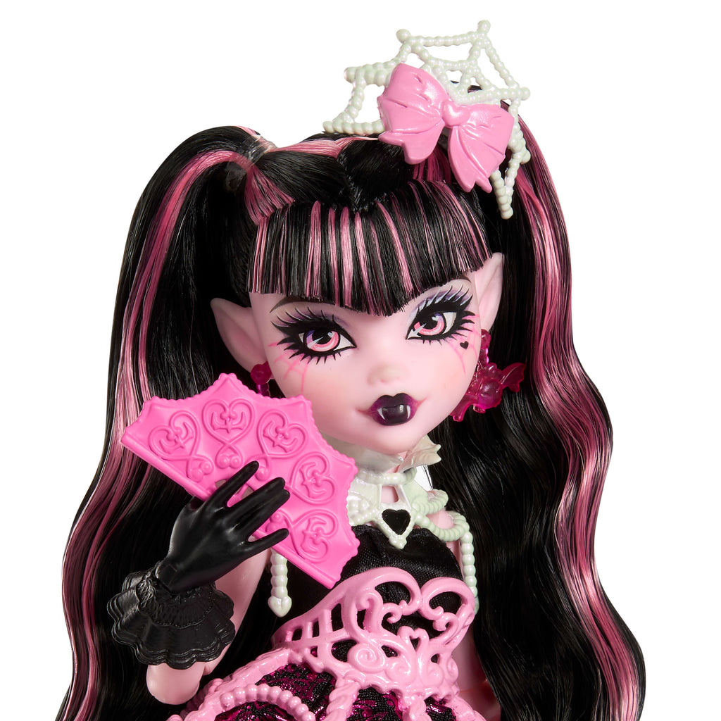 Parti elbisesi giyen ve bir elinde balon, diğer elinde hediyesini tutan Monster High Doğum Günü Draculaura bebek