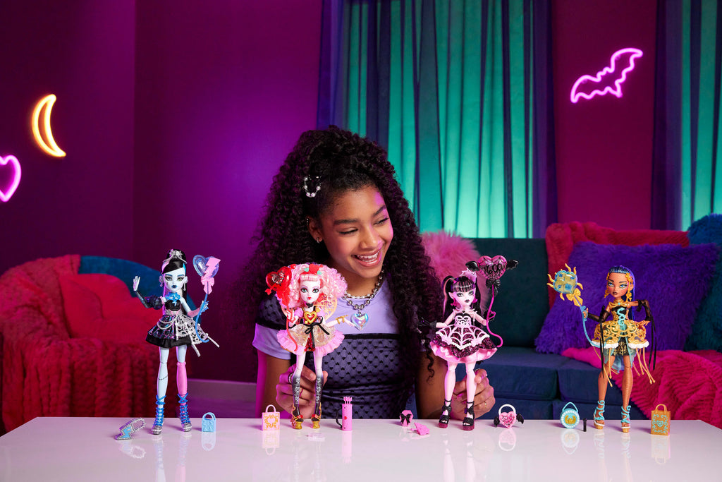 Parti elbisesi giyen ve bir elinde balon, diğer elinde hediyesini tutan Monster High Doğum Günü Frankie Stein bebek