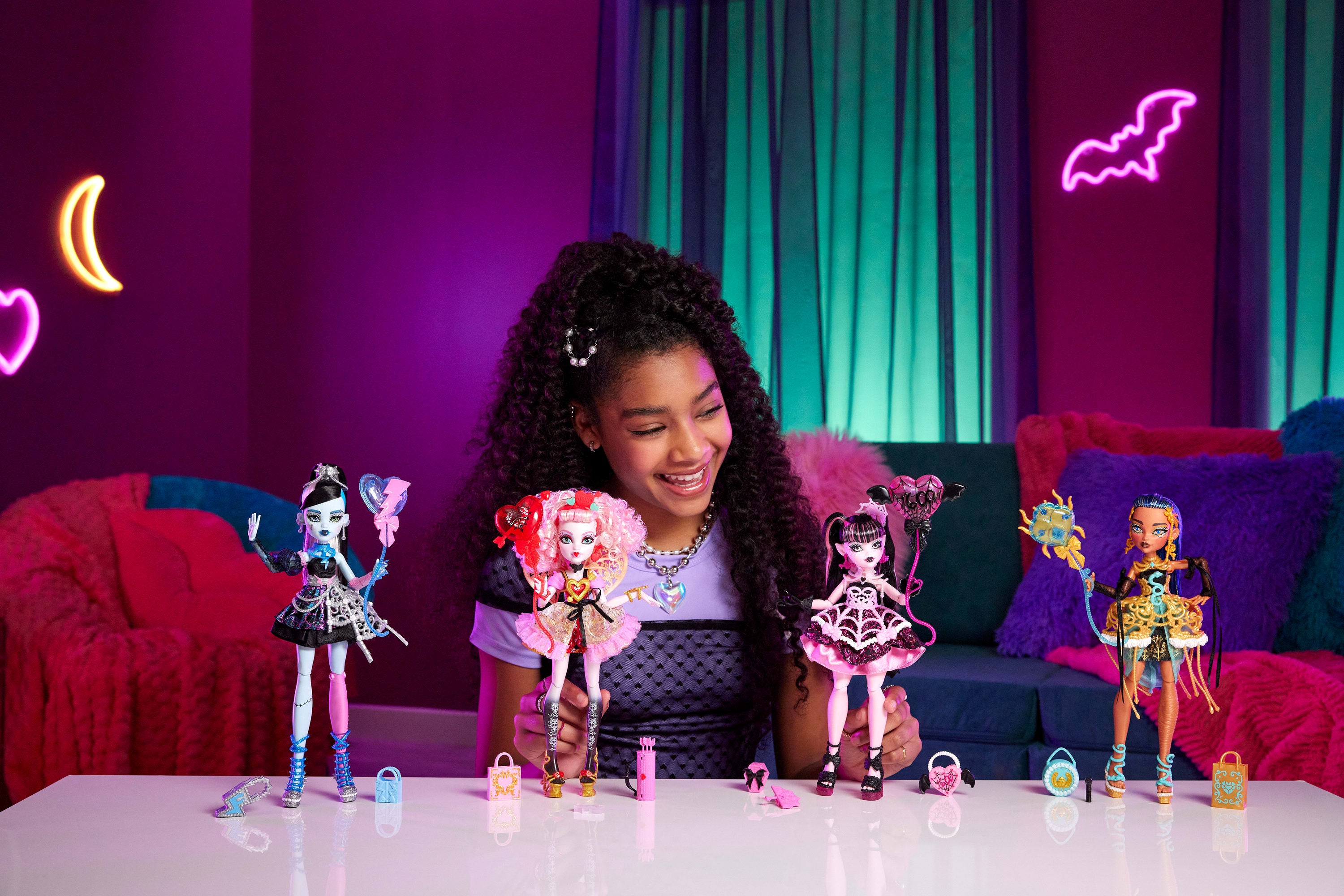 Parti elbisesi giyen ve bir elinde balon, diğer elinde hediyesini tutan Monster High Doğum Günü Frankie Stein bebek