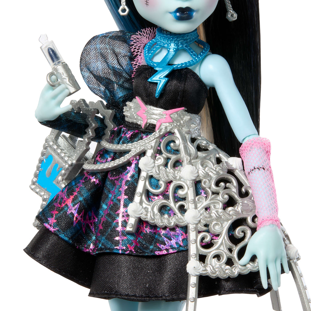 Parti elbisesi giyen ve bir elinde balon, diğer elinde hediyesini tutan Monster High Doğum Günü Frankie Stein bebek