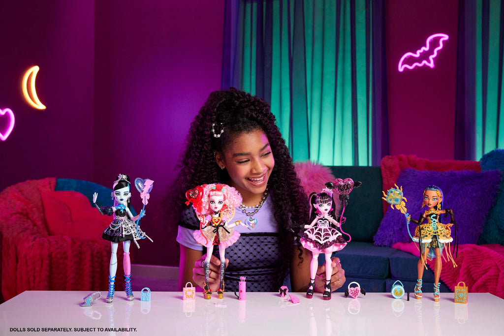 Parti elbisesi giyen ve bir elinde balon, diğer elinde hediyesini tutan Monster High Havalı Doğum Günü Cupid Asteria bebek