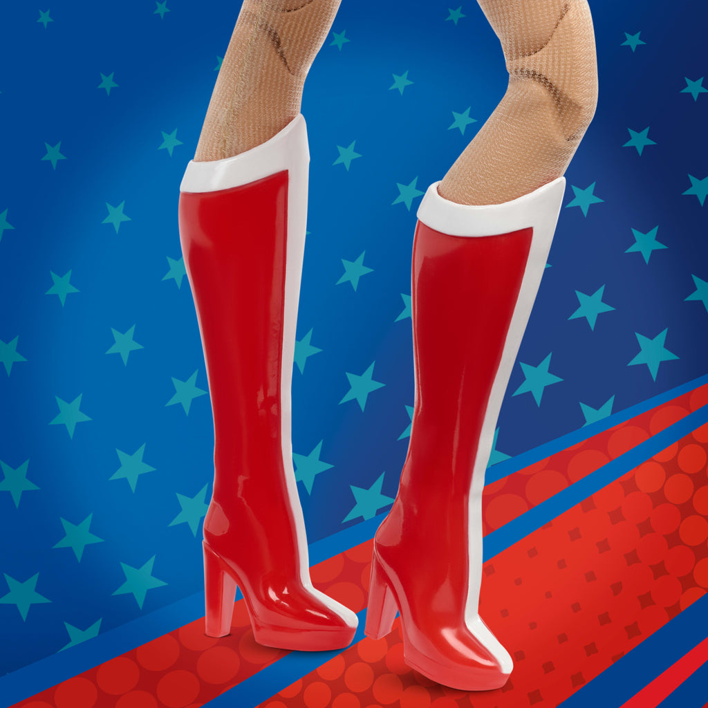 Mavi ve kırmızı renkli tek parça kıyafeti, altın renkli aksesuarları ve kementi ile Koleksiyona uygun Barbie Wonder Woman bebek