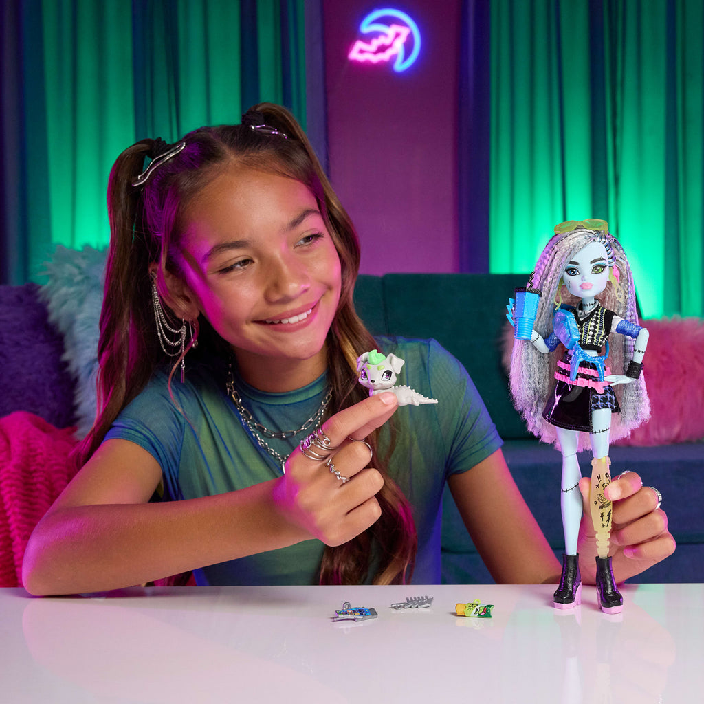 Evcil dostu Watzie ve 7 aksesuarla siyah suni deri etek giyen Monster High Frankie Stein bebek