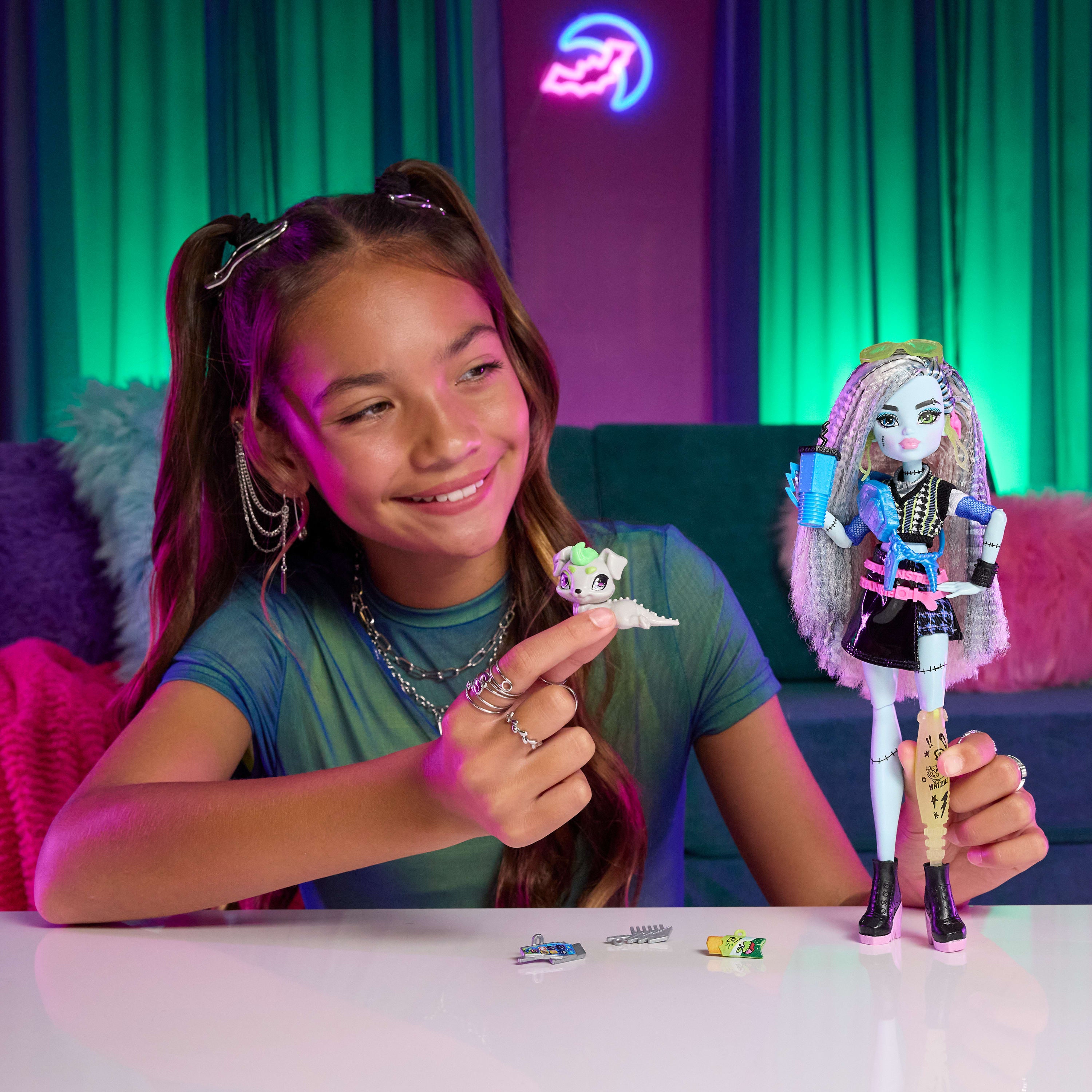 Evcil dostu Watzie ve 7 aksesuarla siyah suni deri etek giyen Monster High Frankie Stein bebek