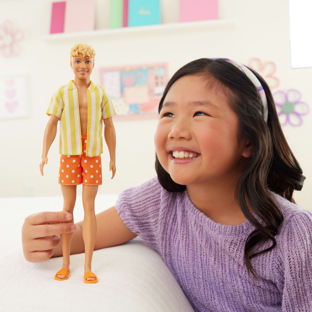 Barbie Fashionistas Style Ken bebek (252), turuncu ve sarı puantiyeli şort ile sarı ve beyaz çizgili üst giyen sarı saçlı bebek